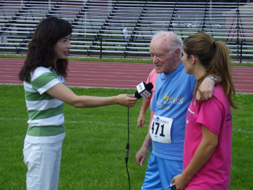Mike and granddaughter Kate being interviewed by Chinese TV after the 200 meter dash. The clip was broadcast in China in a piece about athletically active elders.